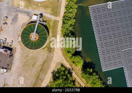 Luftaufnahme Solarkraftwerk schweben den Teich in der Nähe von Umwälzsedimentierung Tank, Wasseraufbereitungsanlage Stockfoto