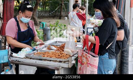 Käufer und Verkäufer authentisches Geld wechseln die Hände Klong Toey Market BangkokThailand die Wirtschaft der Lebensmittelverkäufe Menschen kaufen Mittagessen Rama 4 Kreuzung Stockfoto