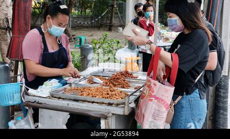 Käufer und Verkäufer authentisches Geld wechseln die Hände Klong Toey Market BangkokThailand die Wirtschaft der Lebensmittelverkäufe Menschen kaufen Mittagessen Rama 4 Kreuzung Stockfoto