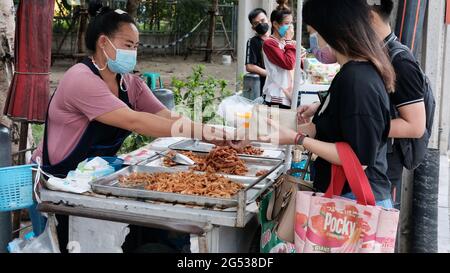 Käufer und Verkäufer authentisches Geld wechseln die Hände Klong Toey Market BangkokThailand die Wirtschaft der Lebensmittelverkäufe Menschen kaufen Mittagessen Rama 4 Kreuzung Stockfoto