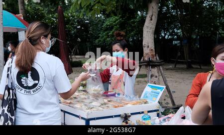 Käufer und Verkäufer authentisches Geld wechseln die Hände Klong Toey Market BangkokThailand die Wirtschaft der Lebensmittelverkäufe Menschen kaufen Mittagessen Rama 4 Kreuzung Stockfoto