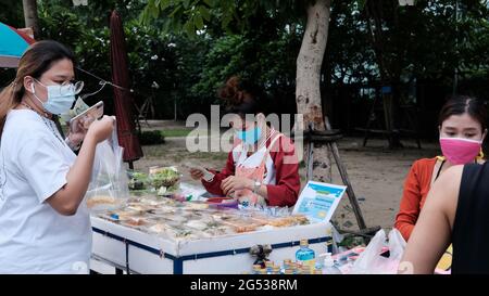 Käufer und Verkäufer authentisches Geld wechseln die Hände Klong Toey Market BangkokThailand die Wirtschaft der Lebensmittelverkäufe Menschen kaufen Mittagessen Rama 4 Kreuzung Stockfoto