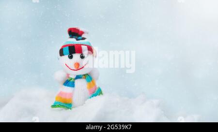 Frohe weihnachten und eine Grußkarte mit Platz für das neue Jahr. Happy Toy von Schneemann in Mütze und Schal stehen im Winter Schnee Hintergrund. weihnachten Stockfoto