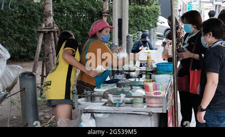 Käufer und Verkäufer authentisches Geld wechseln die Hände Klong Toey Market BangkokThailand die Wirtschaft der Lebensmittelverkäufe Menschen kaufen Mittagessen Rama 4 Kreuzung Stockfoto