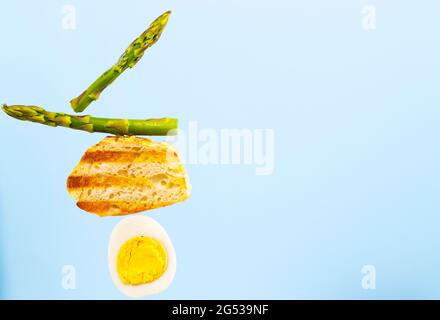 Frisch gegrilltes Brot, Spargel und Ei. Zum Frühstück gibt es Inridients. Gleichgewichtsschwimmende Lebensmittel. Balance Levitation Food. Speicherplatz Kopieren. Essbare Tapete. Stockfoto