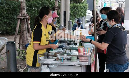 Käufer und Verkäufer authentisches Geld wechseln die Hände Klong Toey Market BangkokThailand die Wirtschaft der Lebensmittelverkäufe Menschen kaufen Mittagessen Rama 4 Kreuzung Stockfoto