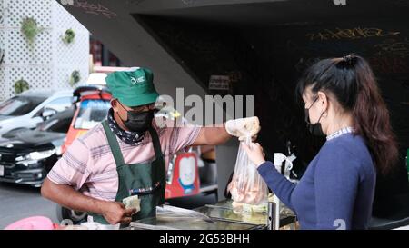 Käufer und Verkäufer authentisches Geld wechseln die Hände Klong Toey Market BangkokThailand die Wirtschaft der Lebensmittelverkäufe Menschen kaufen Mittagessen Rama 4 Kreuzung Stockfoto