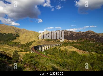 Der Jacobite Steam Train, der das Glenfinnan Viadukt in der Nähe von Fort William in den schottischen Highlands, Großbritannien, überquert Stockfoto