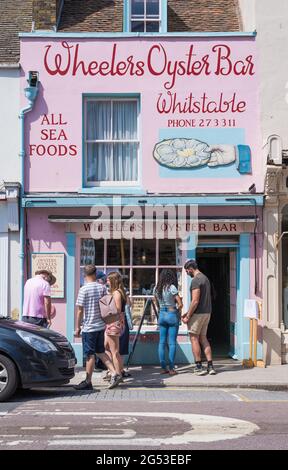 Menschen stehen vor den Rädern Oyster Bar in der High Street, Whitstable, Kent, England, Stockfoto