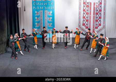 Sliven, Bulgarien - 20. Juni 2021: Junge bulgarische Männer und Frauen, die Volkstänze in traditioneller Kleidung aufführen Stockfoto