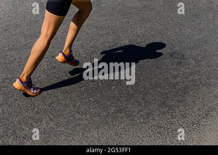Mädchen Läuferin laufen Schatten auf dunkler Straße Stockfoto