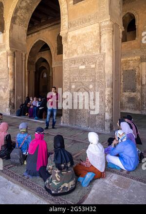 Mann im Gespräch mit einer Gruppe von Frauen vor dem fatimidischen Mihrab in der Moschee von Ibn Tulun, Kairo, Ägypten Stockfoto