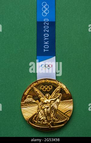 25. April 2021 Tokio, Japan. Goldmedaille der XXXII. Olympischen Sommerspiele in Tokio auf grünem Hintergrund. Stockfoto