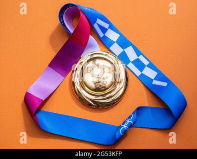 25. April 2021 Tokio, Japan. Goldmedaille der XXXII. Olympischen Sommerspiele in Tokio auf gelbem Hintergrund. Stockfoto