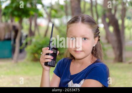 Das kleine Mädchen hält ein Walkie-Talkie in der Hand. Stockfoto