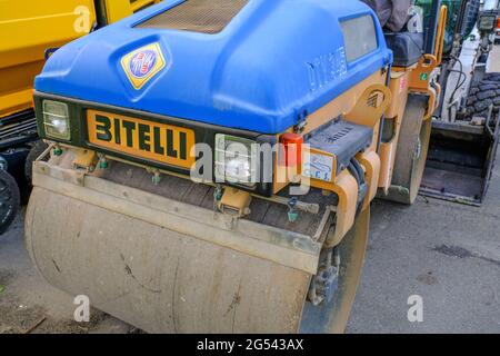 Mai 2021 Parma, Italien: Blaue Asphaltfertiger-Straßenmaschine Bitelli parkte auf anderen schweren Industriemaschinen Stockfoto