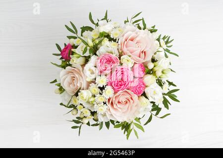 Blumenstrauß auf weißem Holztisch. Draufsicht. Stockfoto