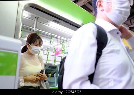 Tokio, Japan. Juni 2021. Passagiere mit Gesichtsmasken als Vorsichtsmaßnahme gegen die Ausbreitung von Covid-19 sahen sich an Bord eines öffentlichen Nahverkehrs am Bahnhof Shinagawa. Kredit: SOPA Images Limited/Alamy Live Nachrichten Stockfoto