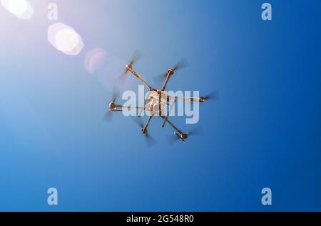 Landwirtschaftliche Drohne im Flug auf einem Hintergrund von blauem Himmel. Neue Technologien im Feld sprühen. Stockfoto