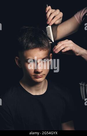 Junger Mann im Friseurladen. Professionelle Frisur. Porträt eines gutaussehenden Mannes mit model Haarschnitt. Neue trendige, moderne Frisur. Barbier scheren Mann ha Stockfoto