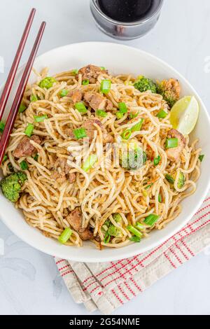 Einfaches Huhn Chow Mein in einer Schüssel auf weißem Hintergrund Top Down Foto Stockfoto