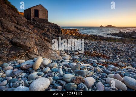 Sonnenuntergang in Priest Cove in der Nähe von St in Cornwall, mit den Brisons Rocks in der Ferne. Stockfoto