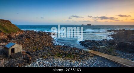 Sonnenuntergang in Priest Cove in der Nähe von St in Cornwall, mit den Brisons Rocks in der Ferne. Stockfoto