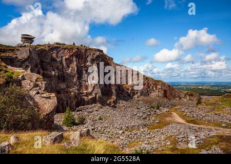 Die natürliche Gesteinsformation „Cheesewring“ scheint über den stillgeratenen Steinbruch „Cheesewring Quarry“ auf Stowe's Hill, Bodmin Moor in Cornwall, prekär ausgeglichen zu sein. Stockfoto