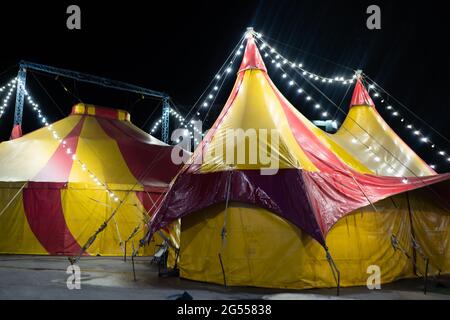 Das bunte Zirkuszelt in der Stadt bei Nacht gegen den Himmel Stockfoto