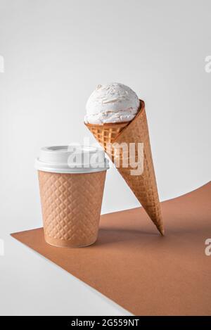 Beigefarbener Einweg-Papierbecher für Kaffee oder Tee und Eis in einem Waffelkegel. Waffelmuster. Vertikale Ausrichtung. Stockfoto