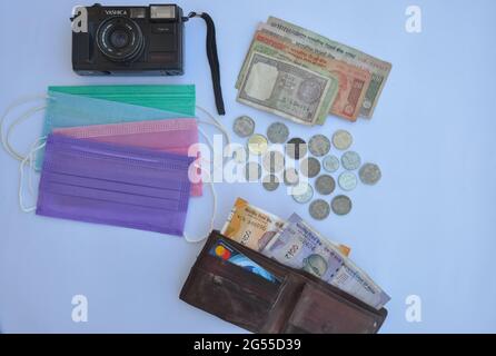 Mandi, Himachal Pradesh, Indien - 04 24 2021: Reisekonzept während des Covid-19, High-Angle-Aufnahme von wichtigen Dingen für Inlandsreisen wie Gesichtsmaske, Geld, mastercard und Kamera. Stockfoto