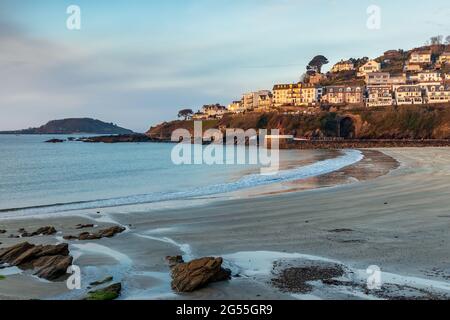 Am frühen Morgen ist es am Strand von Looe in Cornwall hell, mit der Insel Looe am Horizont. Stockfoto