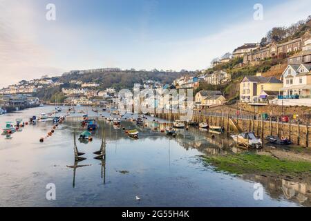 Looe Harbour in Cornwall, aufgenommen am frühen Morgen, als die Sonne ein goldenes Licht über die Szene warf. Stockfoto