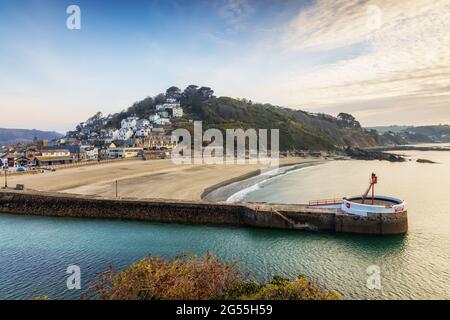 Der Banjo Pier, benannt wegen seiner Banjo-Form, und der Strand bei Looe in Cornwall, kurz nach Sonnenaufgang aufgenommen. Stockfoto