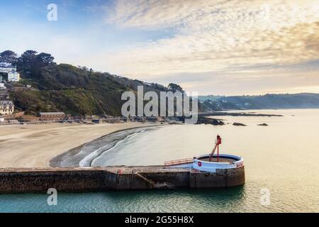 Der Banjo Pier, benannt wegen seiner Banjo-Form, und der Strand bei Looe in Cornwall, kurz nach Sonnenaufgang aufgenommen. Stockfoto