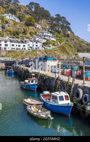 Fischerboote, die an der Hafenmauer in Polperro, einem charmanten und malerischen Fischerdorf im Südosten von Cornwall, festgemacht sind. Stockfoto