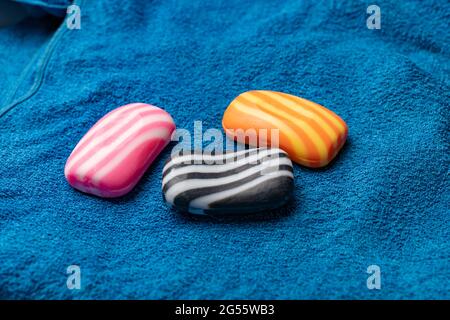 Drei Stück gestreifte Seifenstücke auf dem Handtuch textile Textur, Spa und Bad Verwendung Stockfoto