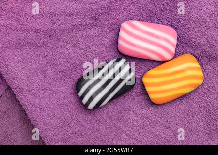 Drei Stück gestreifte Seifenstücke auf dem Handtuch textile Textur, Spa und Bad Verwendung Stockfoto