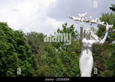 Statue einer jungen Frau, die einen Zweig mit Tauben hält Stockfoto