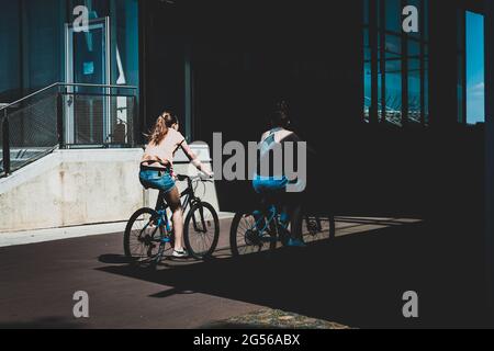 Frauen radeln, teilweise im Schatten, Straßen von Warschau Stockfoto