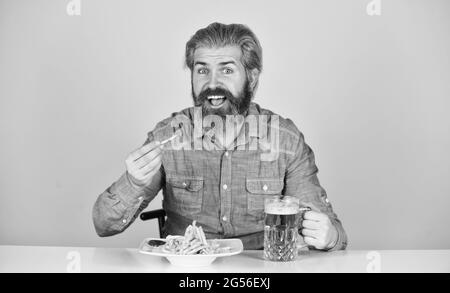 Fußball im Fernsehen. amerikanisches Fast Food. Glücklicher bärtiger Mann mit Bier und pommes. Pommes Frites Kartoffel. Kerl in der amerikanischen Bar Bier trinken Stockfoto