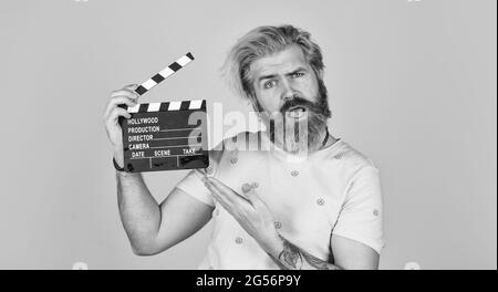 Schauspieler beim Casting. Aufnahmeszene. Lieblingsserie. Aktion. Kinoproduktion. Kreativer Produzent. Bärtiger Mann hält Filmklapper. Filmkonzept Stockfoto