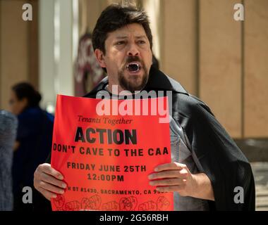 Sacramento, CA, USA. Juni 2021. Der Mieter Jon Goodman aus Antioch, der ein Vampire-Kostüm trägt, protestiert mit Mietern und Fürsprechern vor dem Hauptquartier der California Apartment Association (CAA), um gegen die Aussagen der Organisation zu protestieren, dass am Freitag, den 25. Juni 2021 in Sacramento Zwangsräumungsschutzmaßnahmen aufgrund von COVID''19 nicht mehr erforderlich sind. Quelle: Paul Kitagaki Jr./ZUMA Wire/Alamy Live News Stockfoto