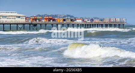 Brechende Wellen in Paignton am Paignton Pier an einem stürmischen Frühlingstag in South Devon. Stockfoto