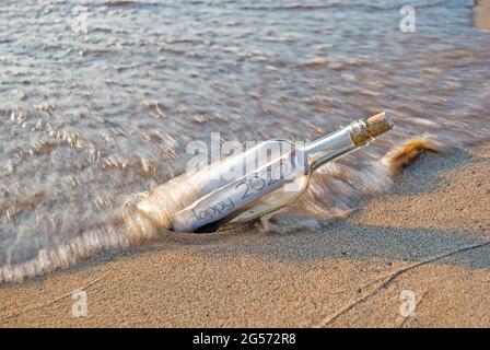 Nachricht für das neue Jahr 2022 in einer Flasche am Strand Stockfoto