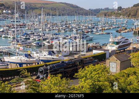 BR Standard Class 4 75014 'Braveheart' am Bahnhof Kingswear auf der Dartmouth Steam Railway, South Devon, mit der Darthaven Marina im Hintergrund. Stockfoto