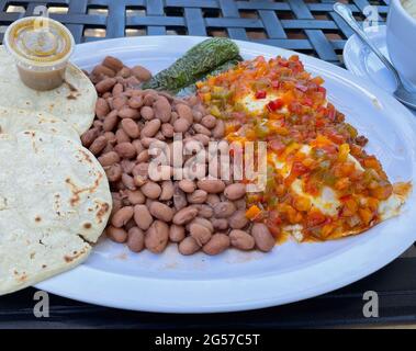 Mexikanisches Frühstück; Huevos Rancheros mit Salsa, Bohnen und Tortillas; Eier mit würziger Sauce, Bohnen und Mais-Tortillas Stockfoto