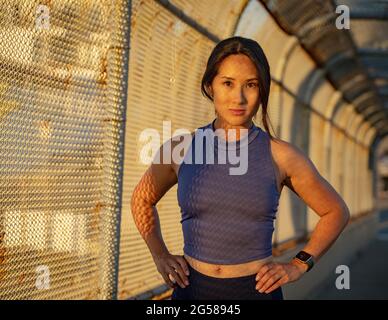 Porträt einer Sportlerin am Zaun Stockfoto