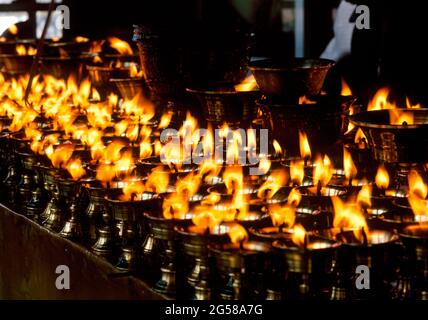 China, Tibet, Lhasa, brennende Kerzen im tibetisch-buddhistischen Tempel Stockfoto