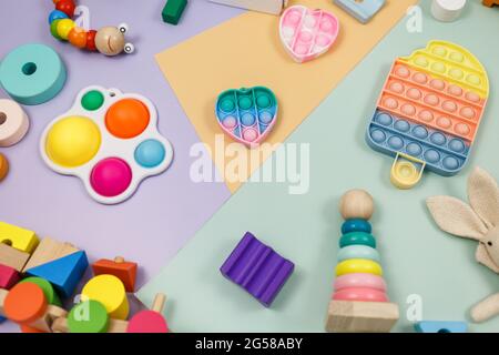 Beliebte Silikon-Anti-Stress-Pop-it-Spielzeug für ein Kind auf violett-grünem Hintergrund. Trendiges Reliever Stress Sensory Fidget Spielzeug. Stockfoto